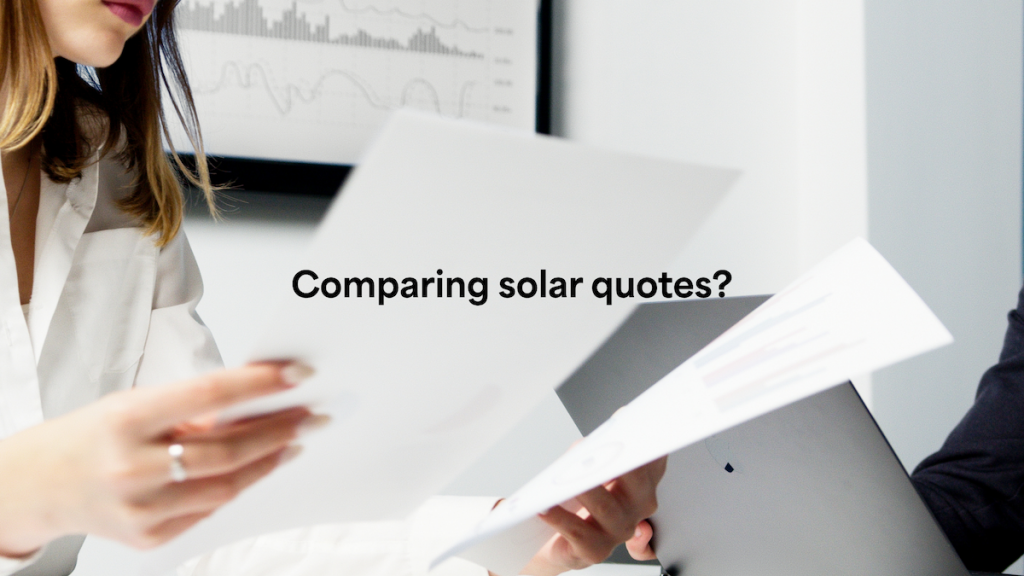 Two people hold papers and a laptop with a graph displayed on the screen, with the text "Comparing solar quotes?" overlaid.